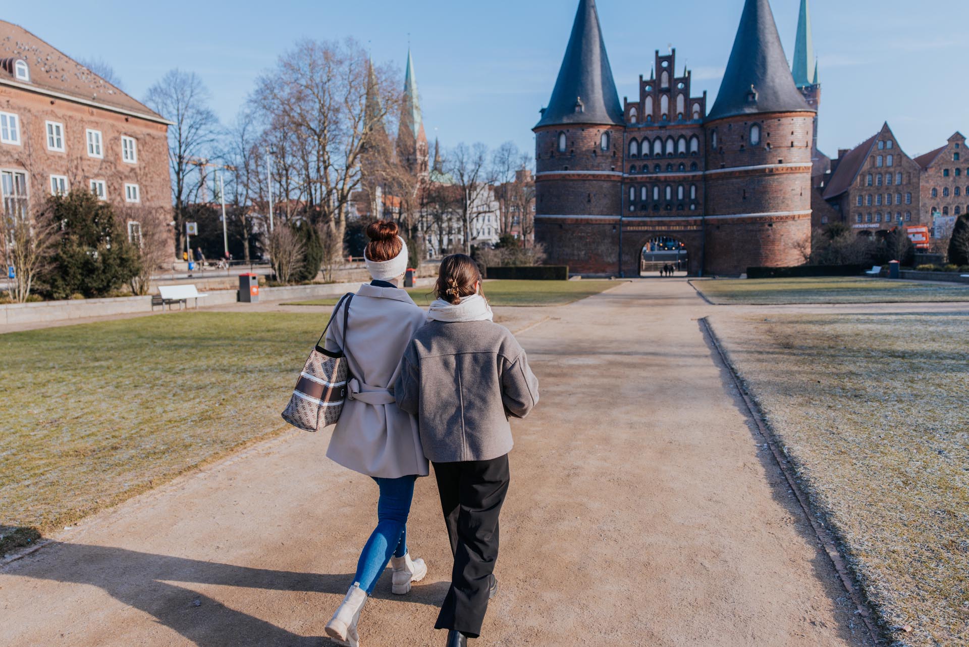 Zwei Personen gehen in Richtung des Holstentors